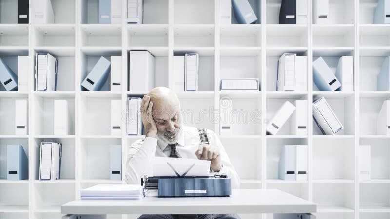 Senior businessman working with a typewriter royalty free stock image Senior businessman working with a typewriter royalty free stock image
