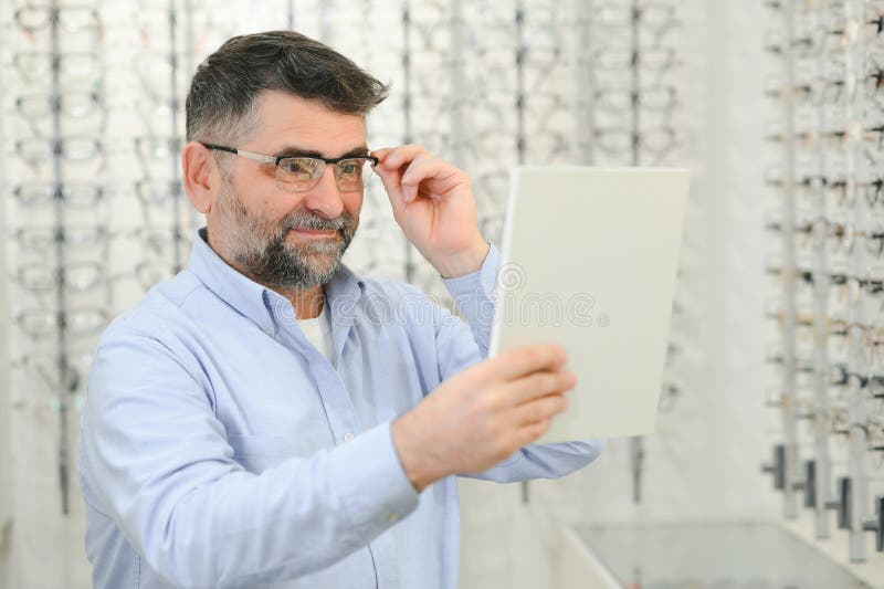 Senior Man Choosing Glasses in Optical Store, Try on Eyeglass Frames To ...