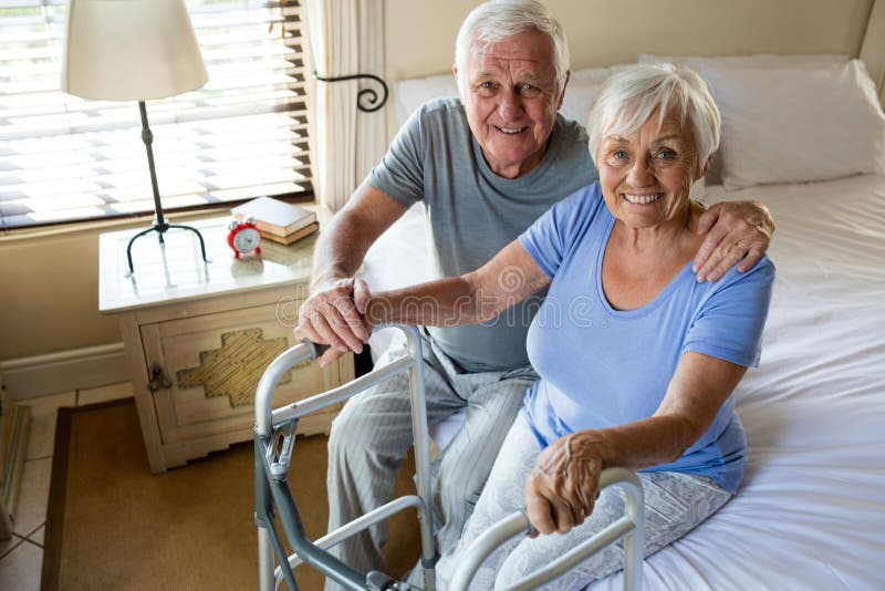 Senior man consoling woman in bedroom at home