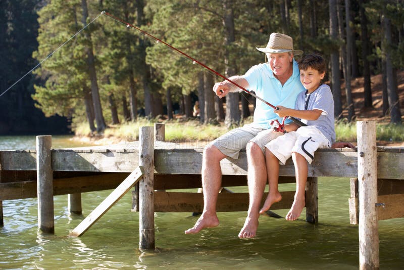 Senior uomini di pesca con nipote sull'estremità del molo.