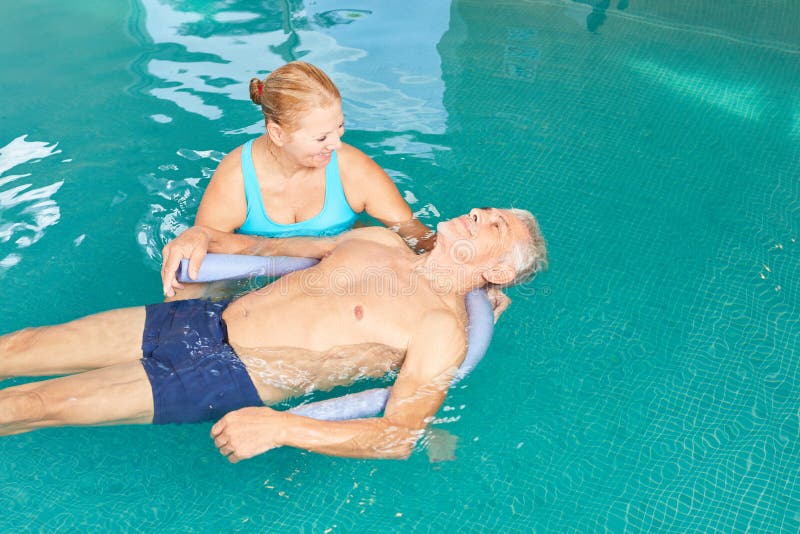 Senior man gets hydrotherapy in the swimming pool