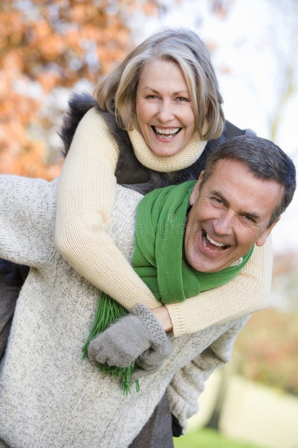 Senior man giving woman piggyback ride