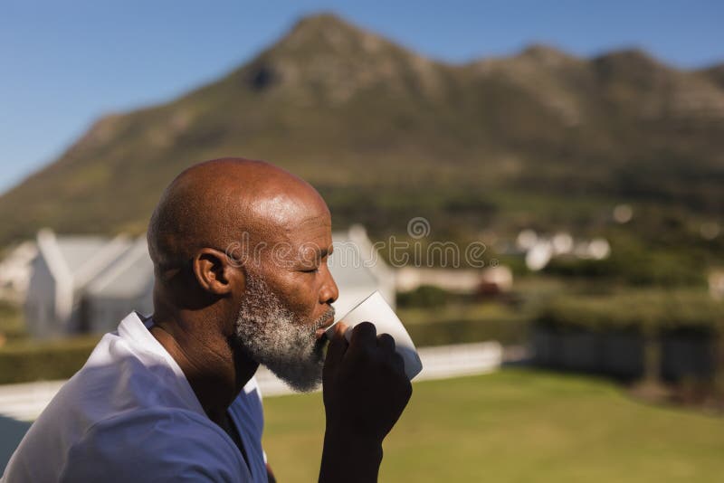 Senior man having coffee on the balcony