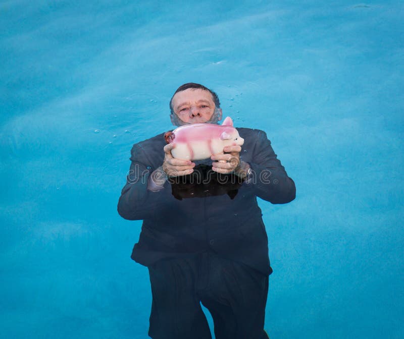 Senior man holding piggy bank above water