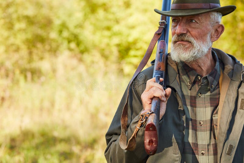 senior-man-hunter-holding-shotgun-shoulder-senior-caucasian-man-hunting-gun-looking-away-man-grey-beard-wearing-161669184.jpg