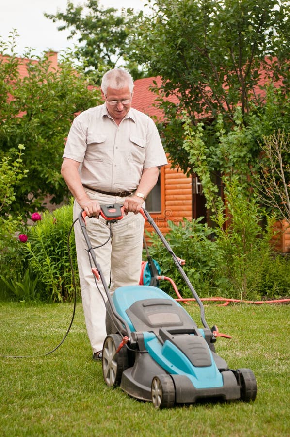 Senior man with lawn mower royalty free stock photo