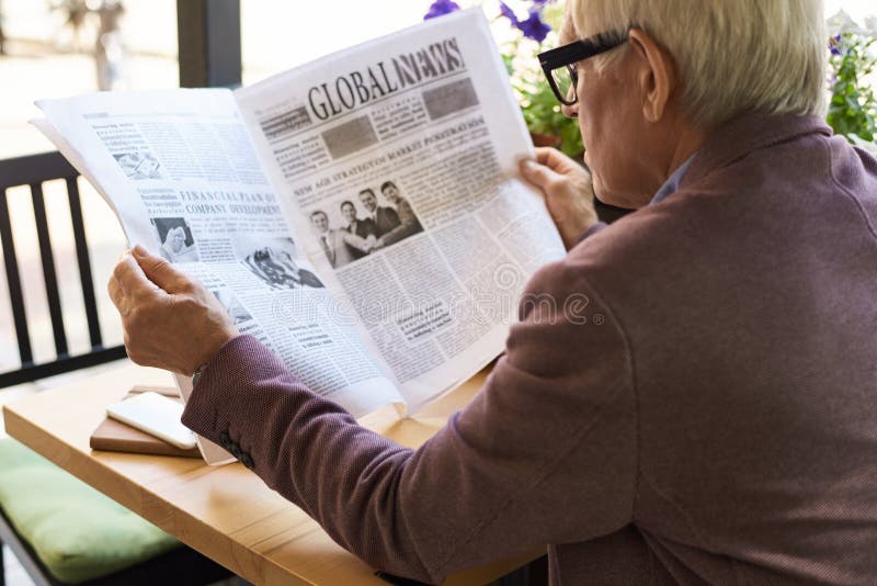 senior man reading newspaper breakfast back view portrait cafe outdoors 99615089