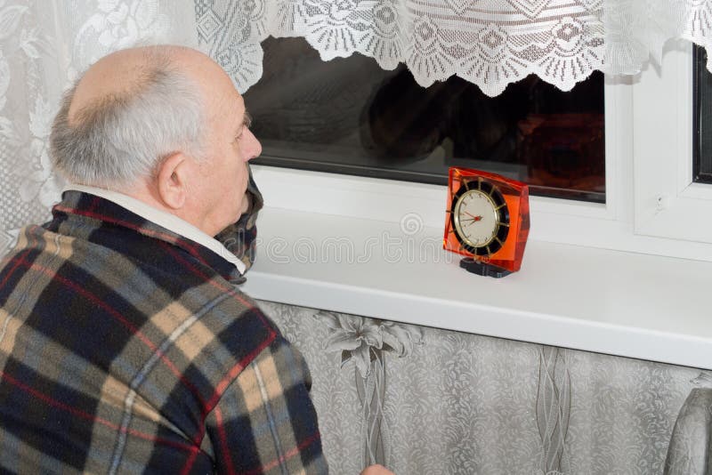 Senior Man Sitting Waiting at Night with a Clock Stock Image Image of