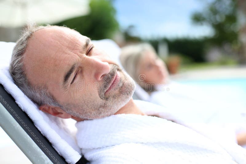 Senior man sleeping in long chair royalty free stock images
