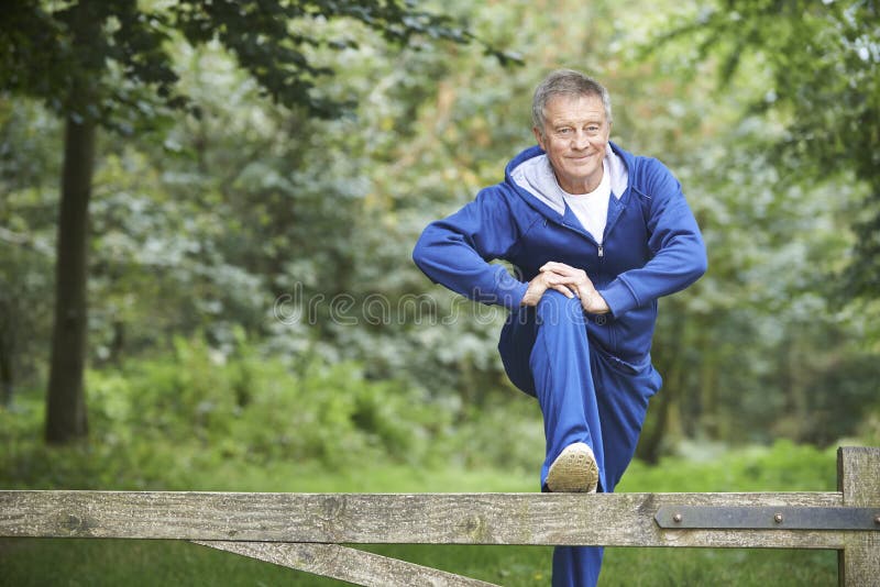 Senior Man Stretching On Countryside Run