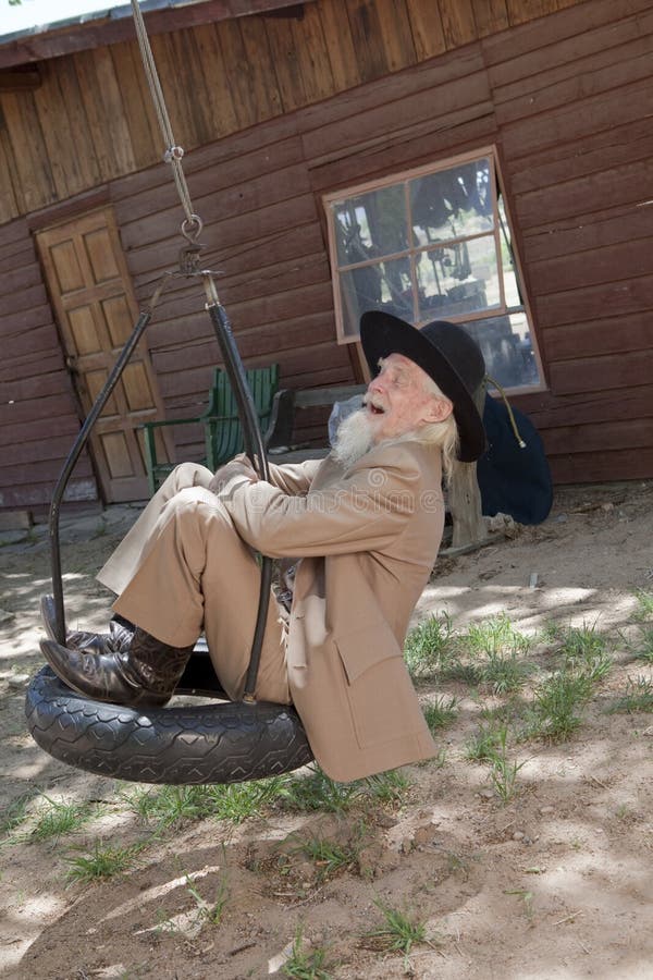 Senior man Swinging on a Tire Swing