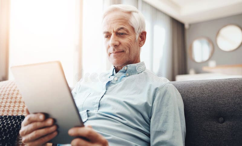 Senior man, tablet and relax on couch in home for streaming movie, communication and reading news. Elderly person stock images