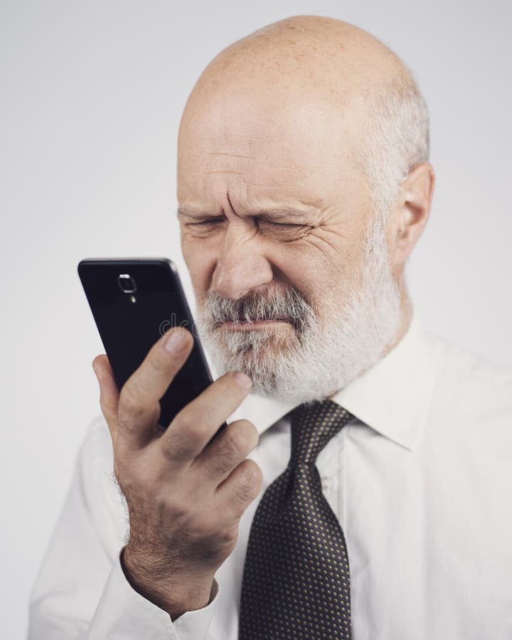 Senior man using a phone and having eyesight problems stock images Senior man using a phone and having eyesight problems stock images