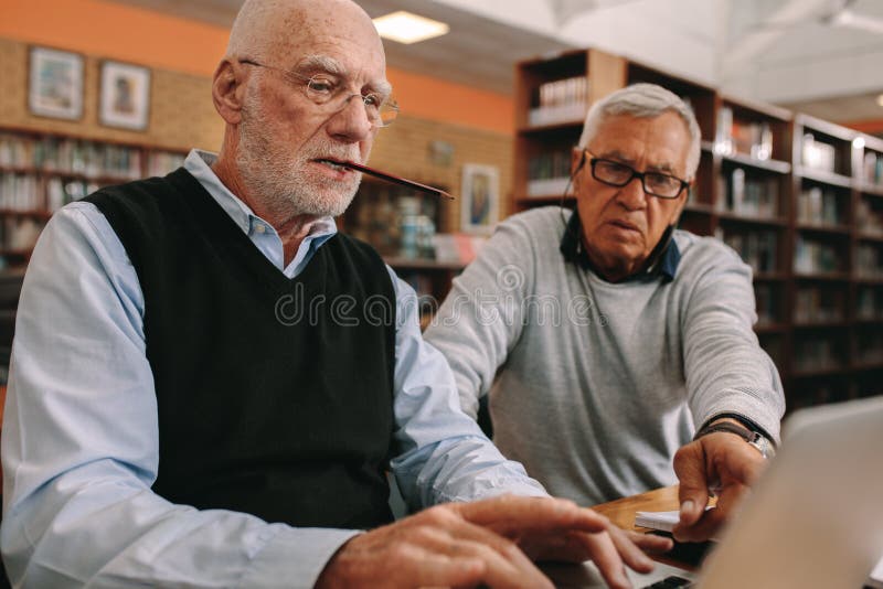 Senior men sitting in a classroom working on laptop royalty free stock photos Senior men sitting in a classroom working on laptop royalty free stock photos