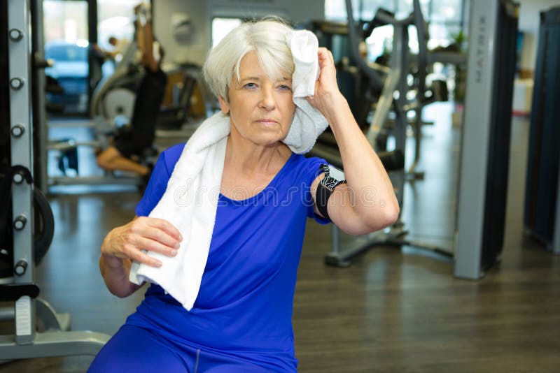 Senior old woman wiping off sweat off forehead