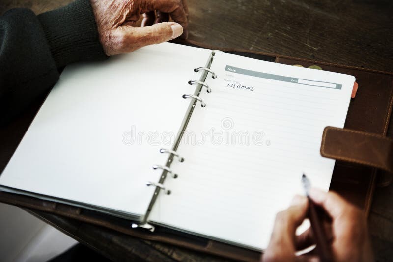 Senior person`s hand writing a journal