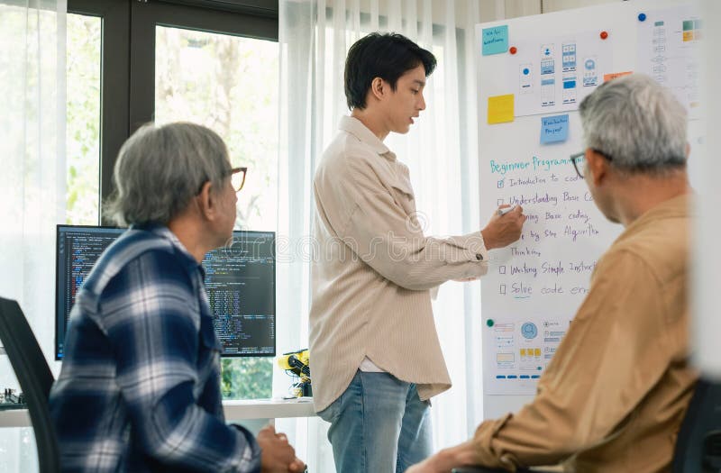 Senior programmer bootcamlp,Asian young instructor guides senior learners through a programming on whiteboard, highlighting algorithm thinking and simple code exercises. Project algorithm stock images, royalty-free photos and pictures