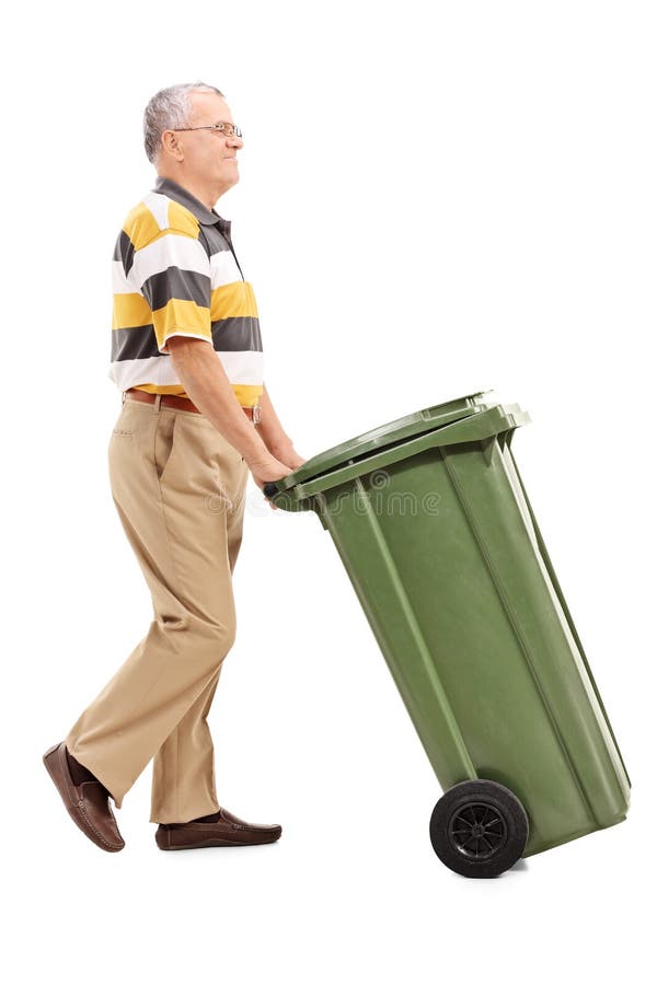 Senior pushing a large green trash can stock photography