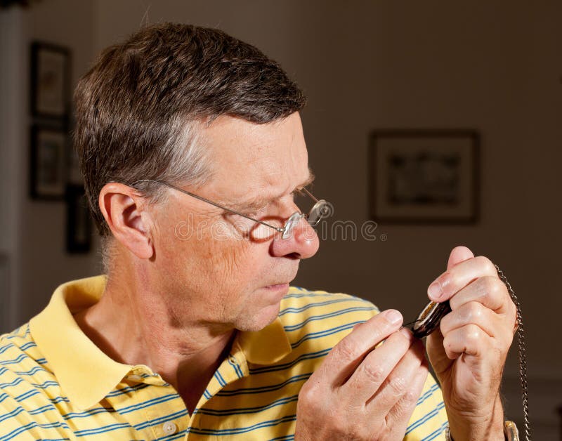 Senior repairing pocket watch stock images