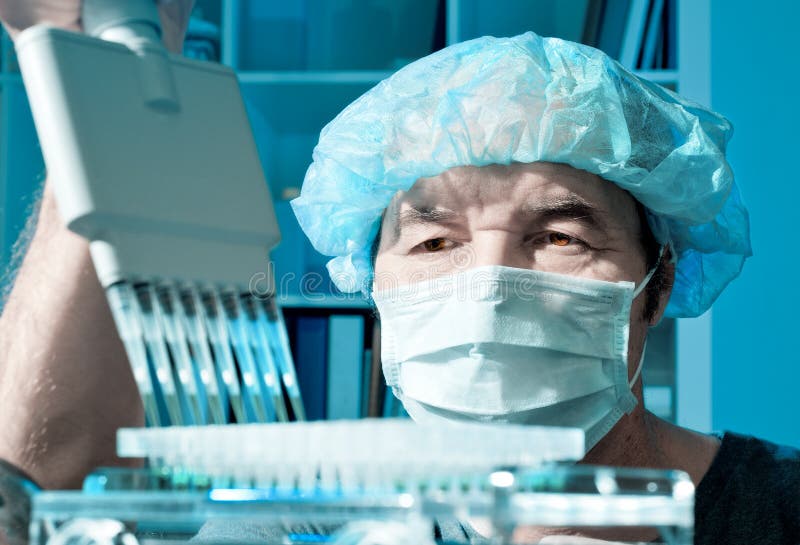 Senior scientist loads samples for DNA analysis royalty free stock photography