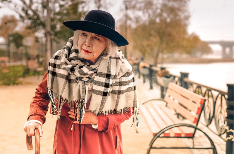 Senior stylish lady taking a walk in park suddenly experiencing chest pain royalty free stock images Senior stylish lady taking a walk in park suddenly experiencing chest pain royalty free stock images