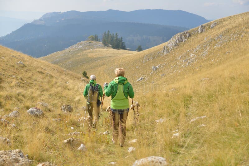 Senior tourist couple hiking at the beautiful mountains