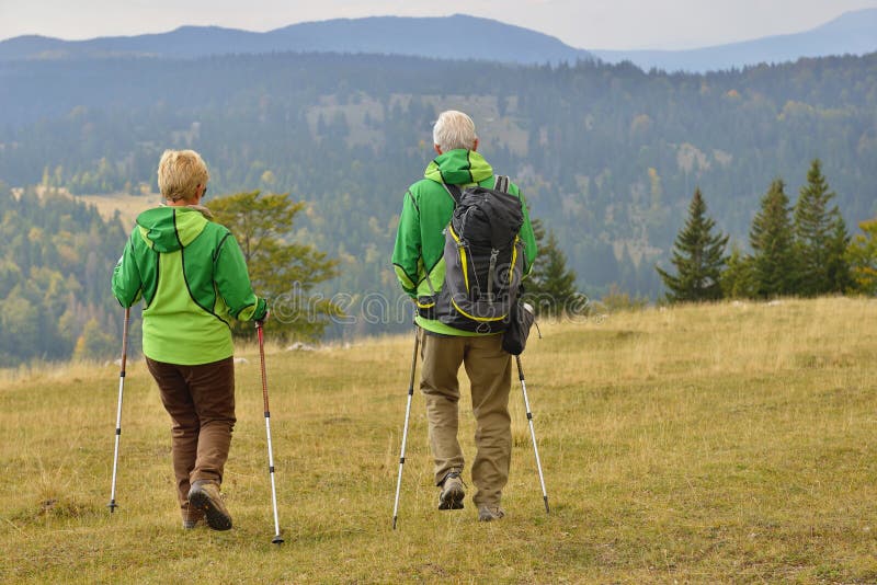 Senior tourist couple hiking at the beautiful mountains