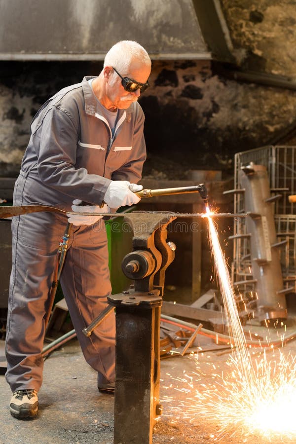 Senior Welder Working and Protective Equipment with Spark Welding Stock
