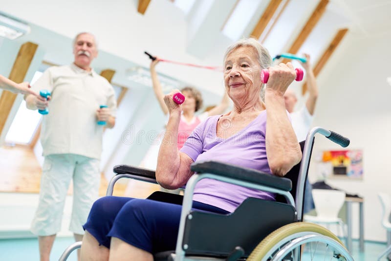 Senior in a wheelchair exercises fitness with dumbbells royalty free stock photo Senior in a wheelchair exercises fitness with dumbbells royalty free stock photo