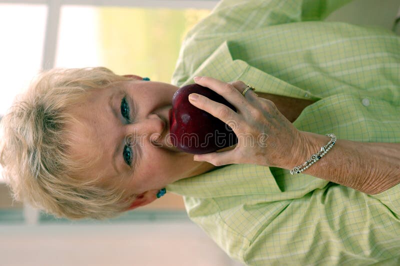 Senior woman biting apple royalty free stock photos Senior woman biting apple royalty free stock photos