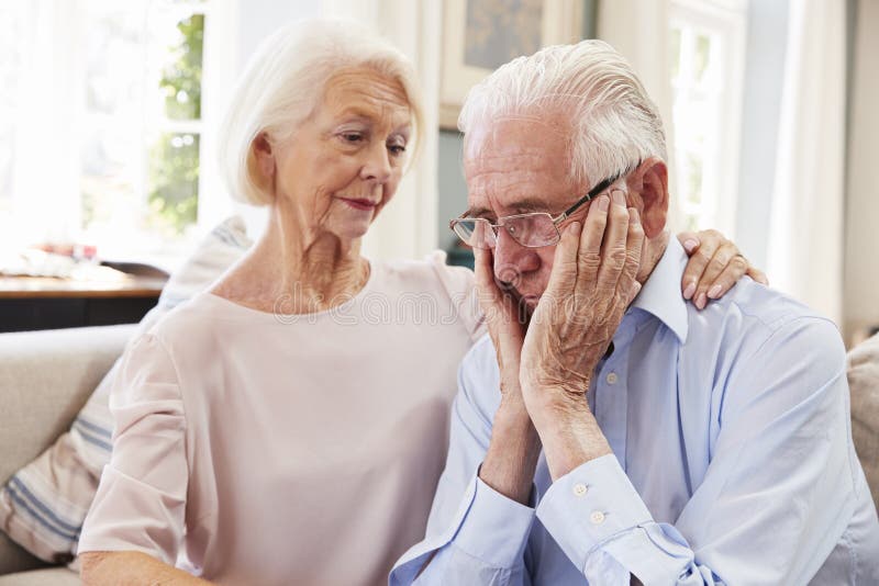 Senior Woman Comforting Man With Depression At Home