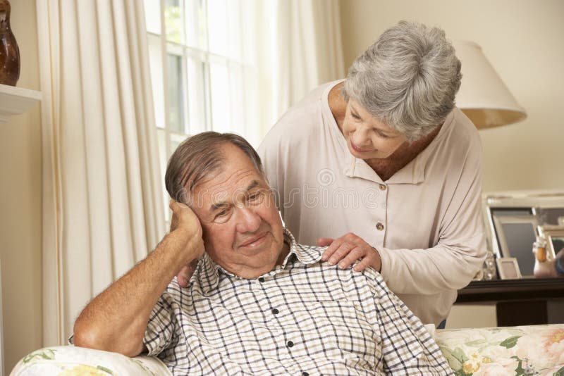Senior Woman Comforting Unhappy Husband At Home stock photo Senior Woman Comforting Unhappy Husband At Home stock photo