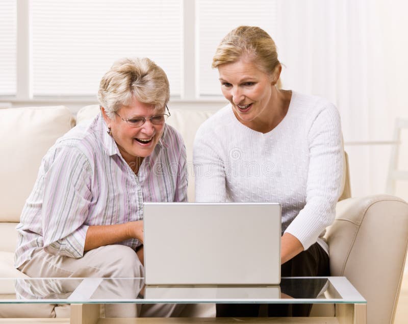 Senior woman and daughter using laptop