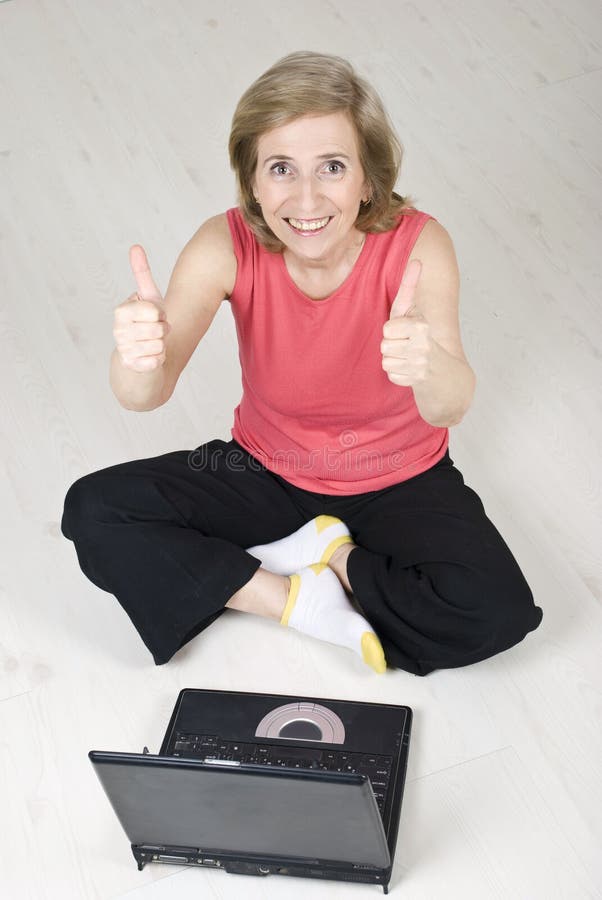 Senior woman giving thumbs up using laptop