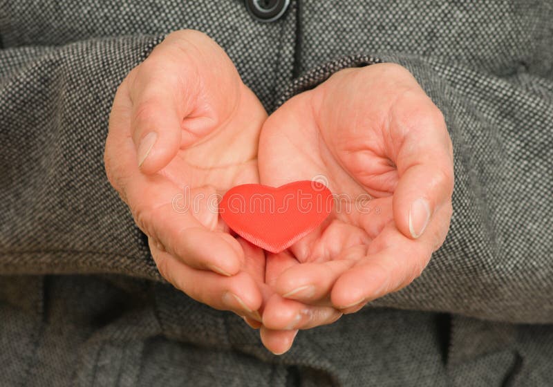 Senior woman hands with red Heart