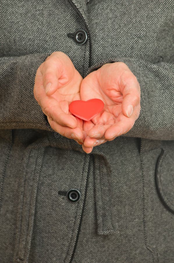 Senior woman hands with red Heart