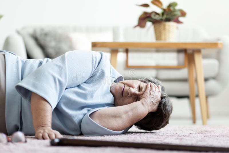 Senior woman with a headache after falling down at home royalty free stock photography Senior woman with a headache after falling down at home royalty free stock photography