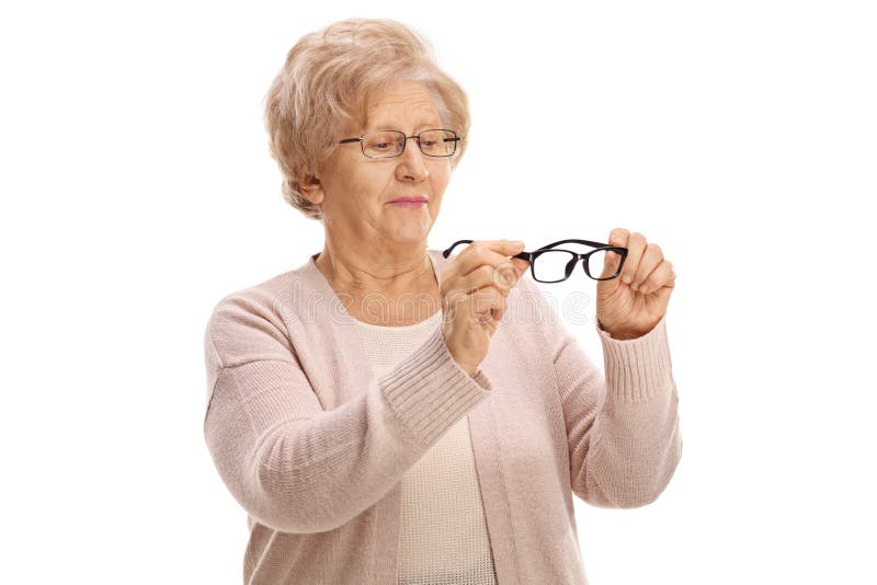 Senior woman holding a pair of new glasses for sight and looking at them