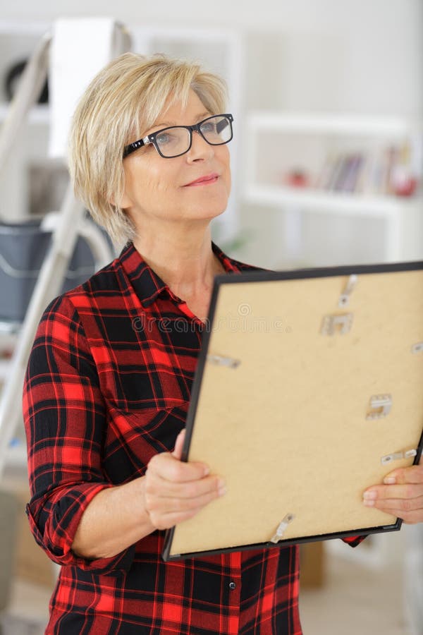 Senior woman holding picture frame stock photo