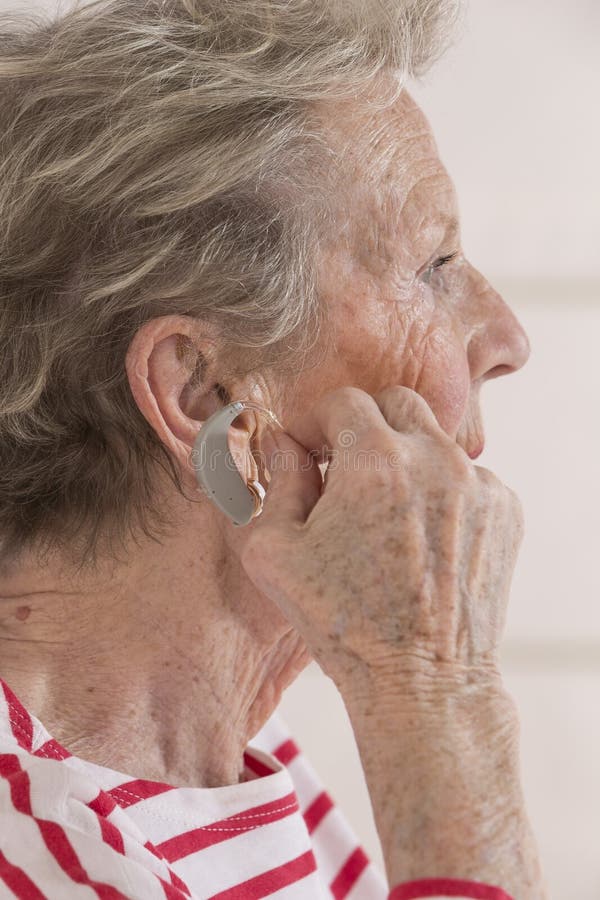 Senior Woman Inserting Hearing Aid in Her Hear. Stock Image Image of