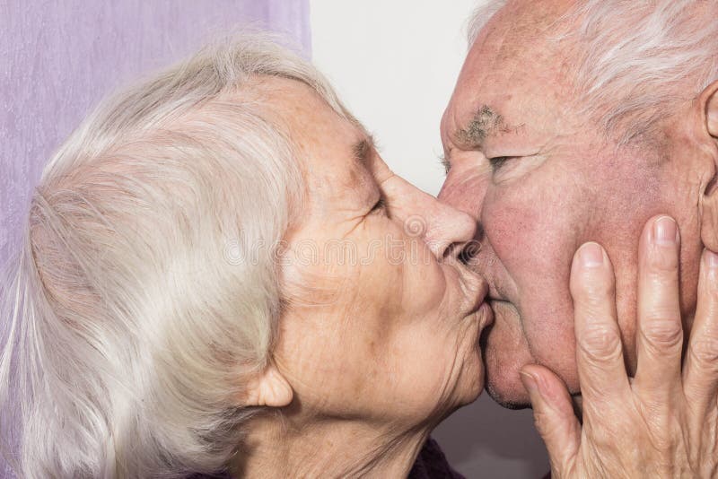 The senior woman kissing old man.
