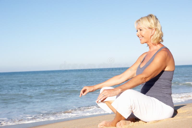 Una mujer en idoneidad la ropa meditación sobre el Playa.