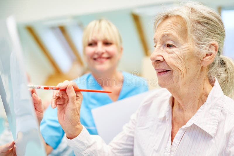 Senior woman in painting class in a painting therapy