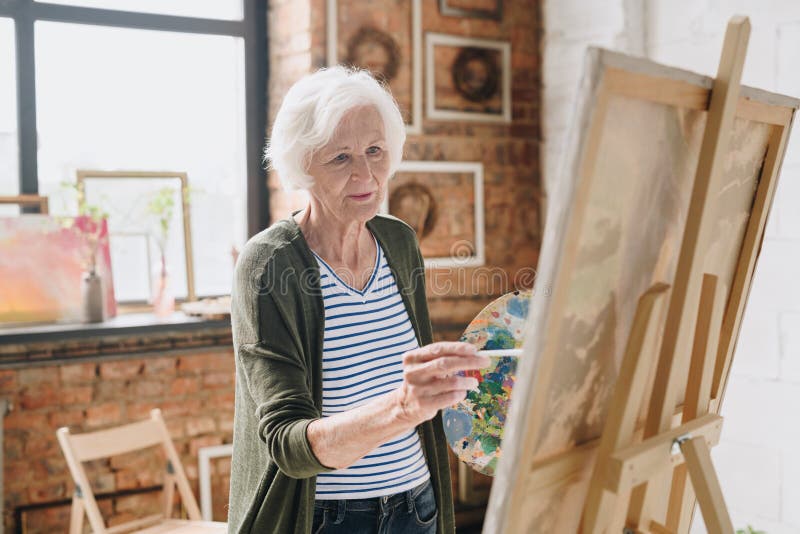 Senior Woman Painting Pictures in Art Studio royalty free stock image Senior Woman Painting Pictures in Art Studio royalty free stock image