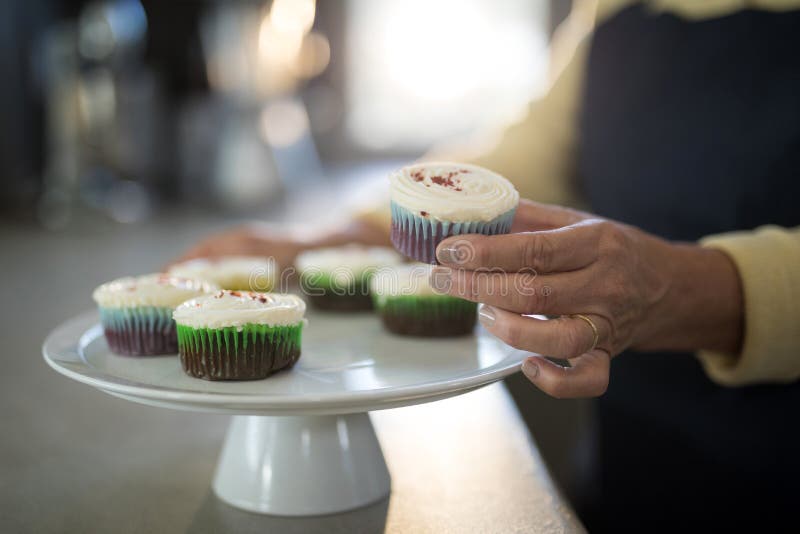 Senior Woman Picking Up the Cupcake from the Tray Stock Photo - Image ...