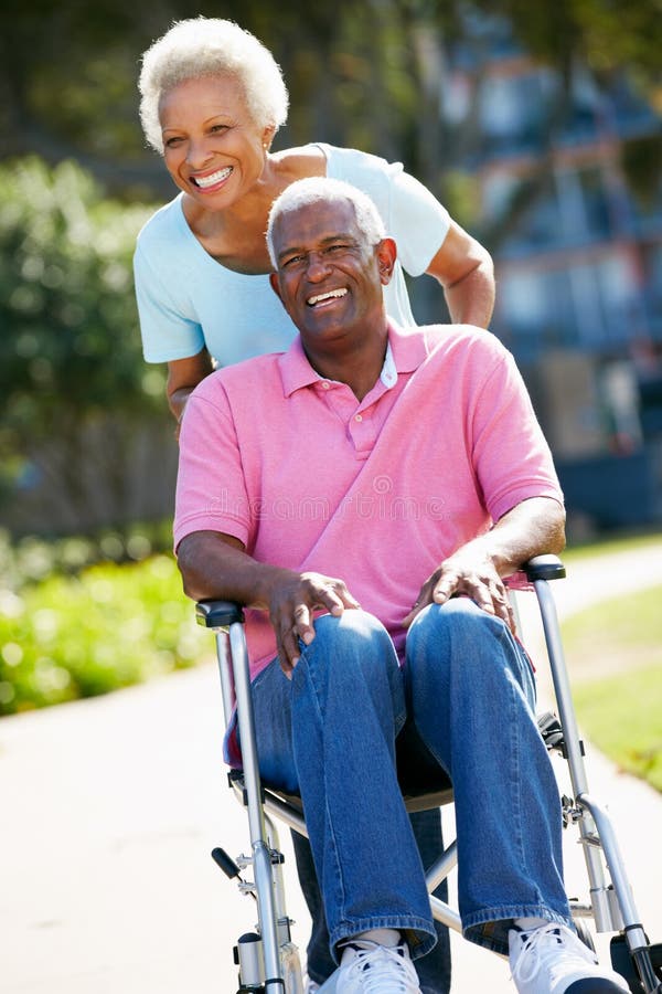 Senior Woman Pushing Husband In Wheelchair