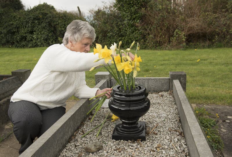 Senior Woman Putting Flowers on a Grave Stock Photo Image of love