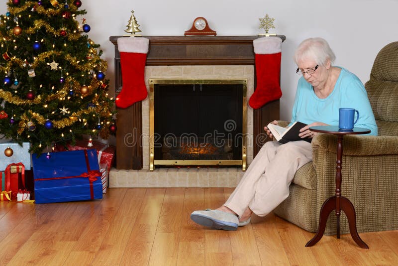 Senior woman reading book in christmas living room stock image Senior woman reading book in christmas living room stock image