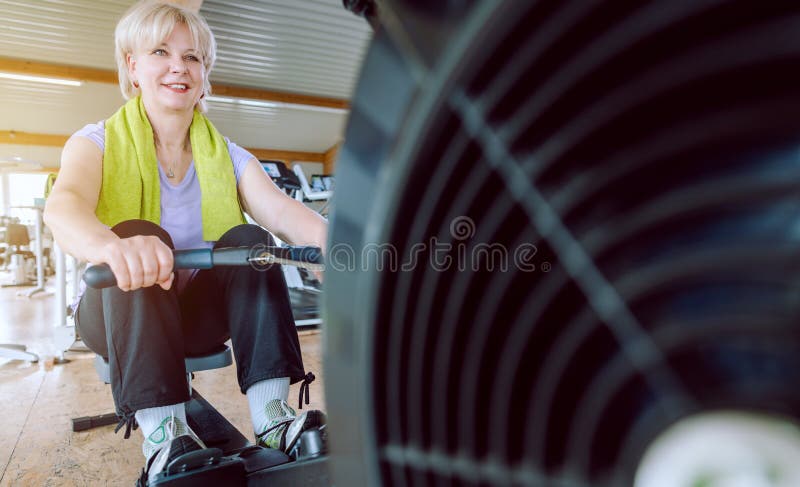 Senior woman on the rowing machine in a fitness gym royalty free stock image Senior woman on the rowing machine in a fitness gym royalty free stock image