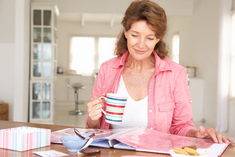 Senior woman scrapbooking drinking tea